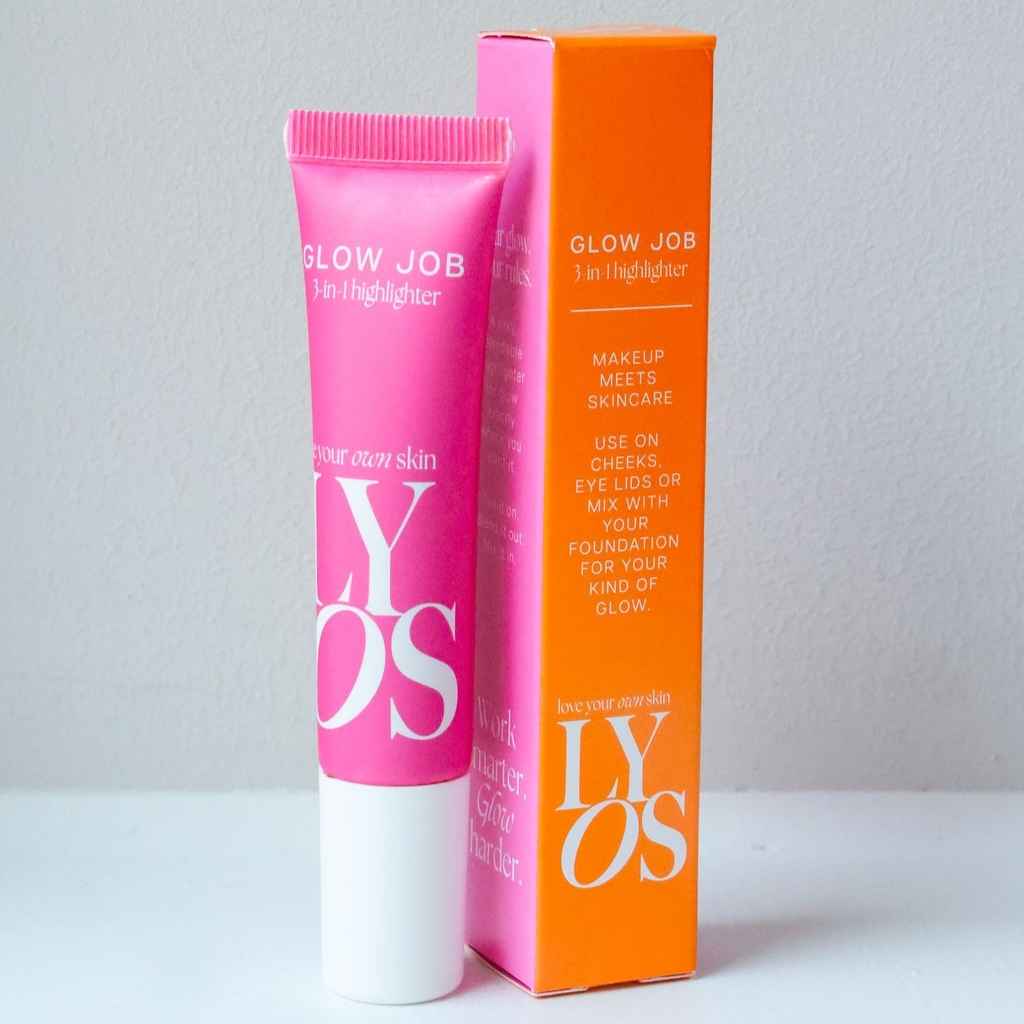 A pink tube of GLOW JOB 3-in-1 Highlighter next to its bright orange packaging box