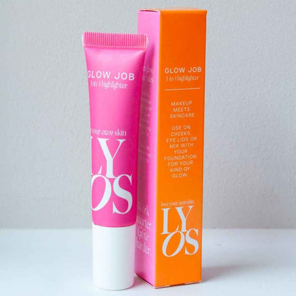 A pink tube of GLOW JOB 3-in-1 Highlighter next to its bright orange packaging box